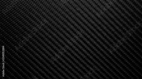 Highresolution black carbon fiber texture featuring a premium twill weave pattern perfect for industrial automotive and hightech design