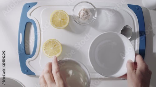 Hands stir Greek yogurt in a bowl while preparing a creamy homemade sauce with fresh ingredients. High quality 4k footage