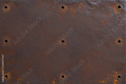 A close up of a rusty metal surface with rivets