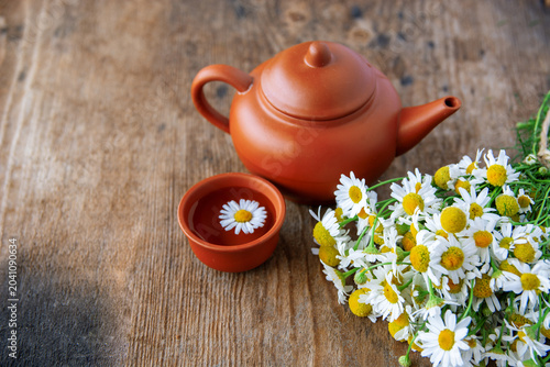 Canvas Print cup of herbal chamomile tea with fresh daisy flowers on wooden background