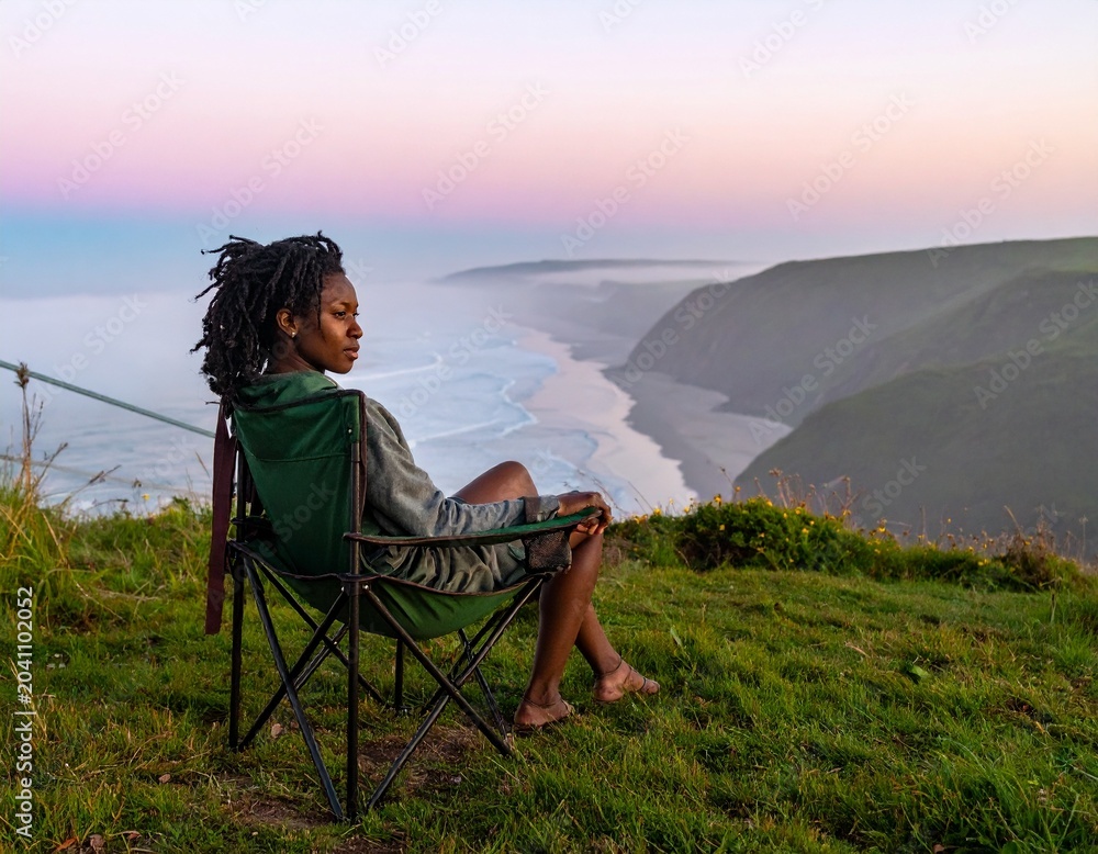 Fototapeta premium woman sitting on a chair at sunset