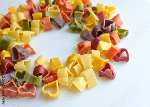 Heart shaped colored pasta on white background