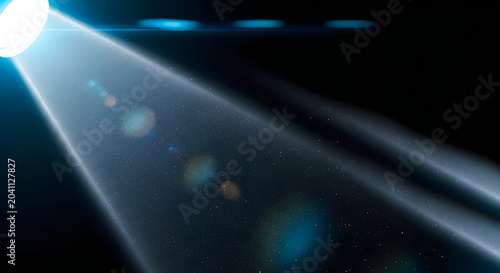Bright light source casting spotlight beam across dark starry space