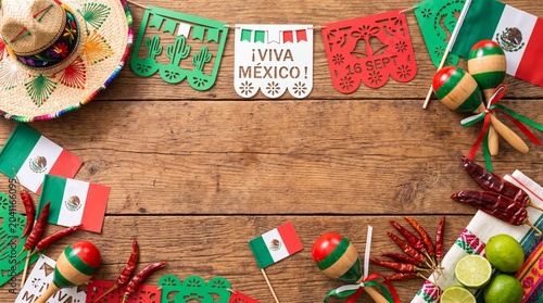 Mexico Independence Day flat lay with papel picado sombrero and maracas on rustic wood