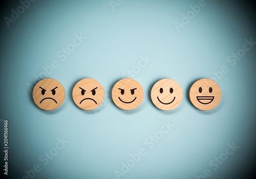 Wooden emoticon faces in a row on blue background