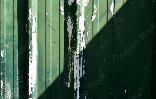 old green peeling paint with sun and shadow