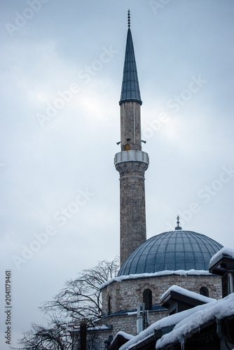 Historic mosque minaret and dome in winter snow