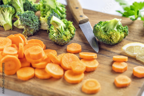 Fresh sliced carrots and broccoli on board