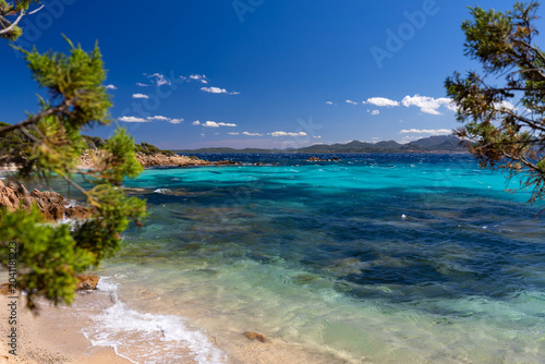 Rocky-sandy coastline with turquoise sea, white sand beach and blue sky in Sardinia, Costa Smeralda, Capriccioli, Italy - background or travel wallpaper
