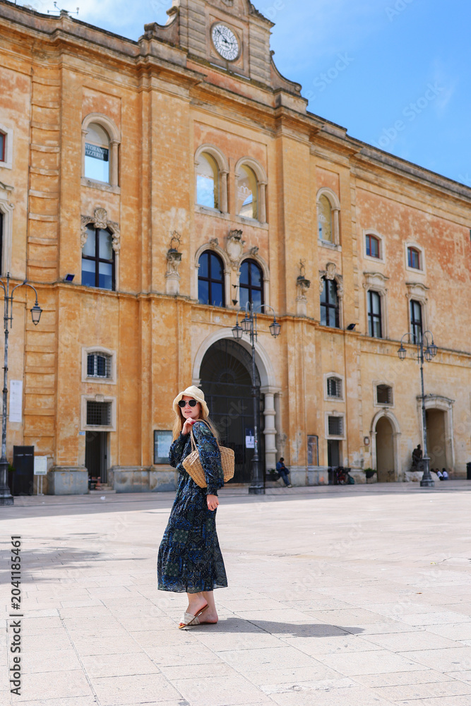 Fototapeta premium Woman walking through a picturesque European destination with historic buildings, leisure travel and vacation lifestyle concept