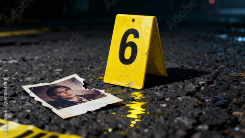 Crime scene evidence marker and victim photograph on wet pavement