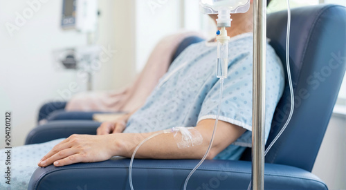 Close up of an IV drip chamber in a hospital. Patient receiving intravenous chemotherapy medication in an oncology infusion clinic. Medical treatment concept