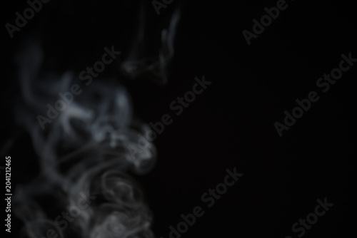 White natural wave smoke abstract texture on black background with copy space. Aroma incense smoke shape curve smooth backdrop