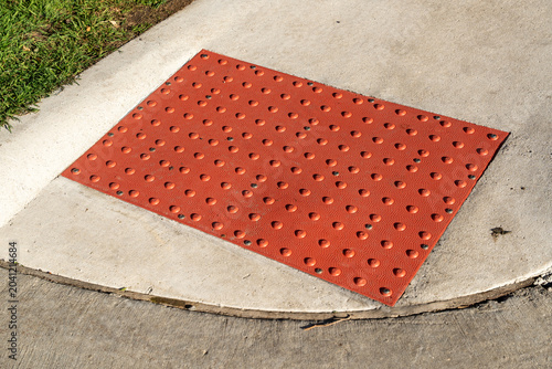 Bild auf Leinwand Red tactile rubber paving on the ground at a pedestrian crossing, designed for v