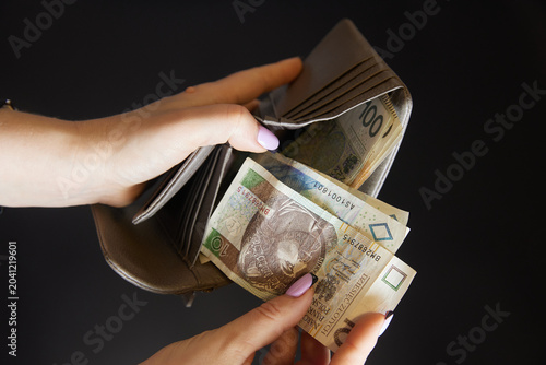 The woman counts the money. Poland. Polish zloty.