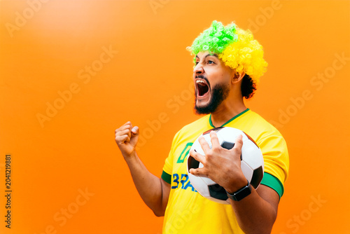 Adult man celebrating victory holding soccer ball