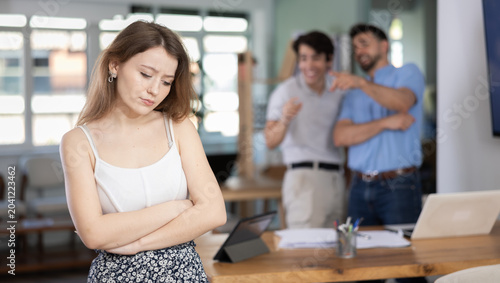 Billede på lærred Angry colleagues scolding sad woman during stressful workday in office