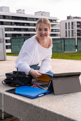 Bild auf Leinwand Young woman student smiling studying on campus outdoors