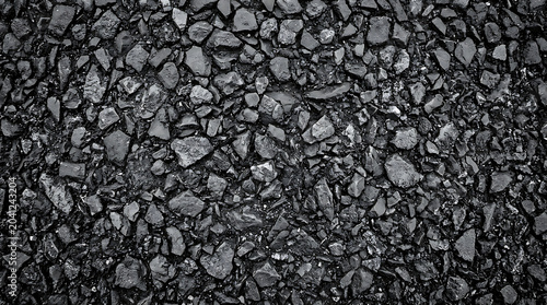 Highcontrast texture of crushed black basalt rocks and bitumen for road paving Industrial dark charcoal coal surface for energy and infrastructure