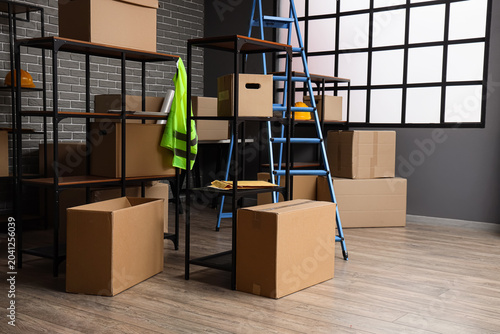 Canvastavla Shelf units with cardboard boxes and stepladder in warehouse interior