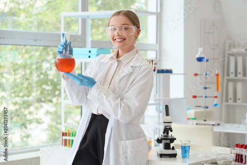 Female chemist with flask in laboratory