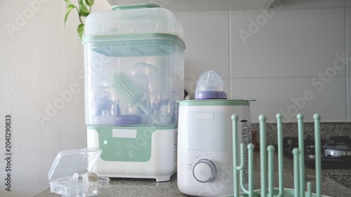 Baby bottle sterilizing machine and warmer appliance on a kitchen countertop for disinfecting