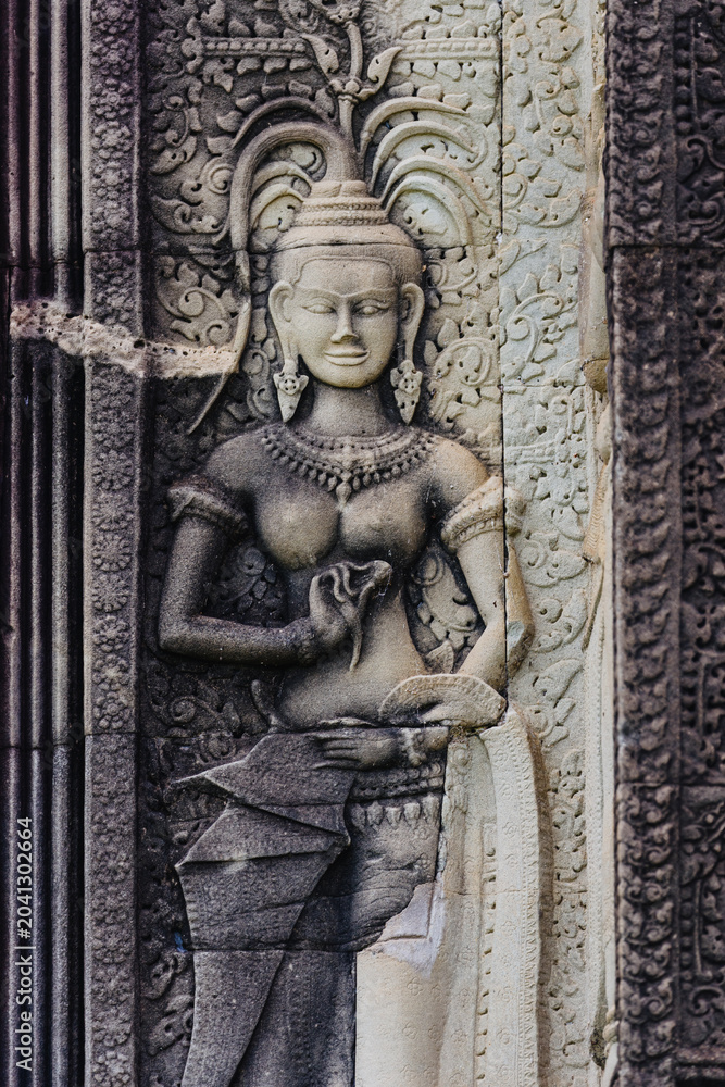 Fototapeta premium Apsara dancer carved in stone at Angkor Wat, Siem Reap, Cambodia. These celestial dancers are a common motif in Khmer art and architecture.
