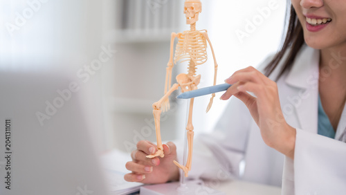 Cuadro en lienzo Asian female doctor explaining skeletal anatomy bone structure using model teach