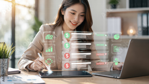 Professional woman analyzes financial data on digital tablet, showcasing income and expense metrics with visual graphs. modern office setting enhances her focused expression and productivity