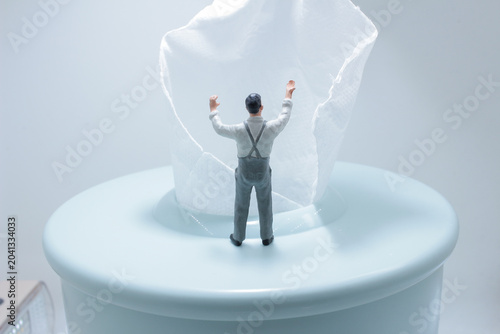 Miniature figure lifting tissue conceptual scene