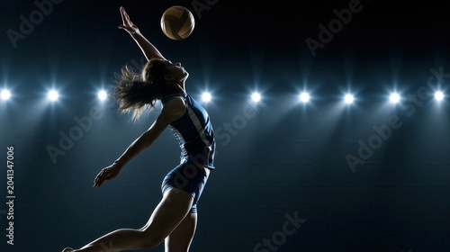 Female volleyball player jumping to spike the ball under stadium lights.