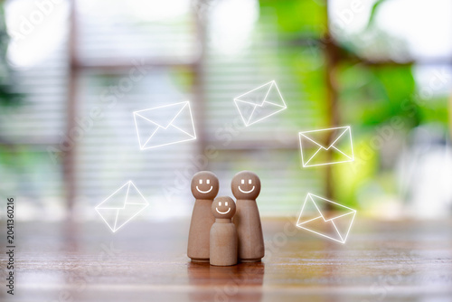Foto Happy wooden family figures surrounded by email icons symbolizing customer communication email marketing, subscriber engagement digital messaging, CRM strategy, customer support, newsletter campaigns