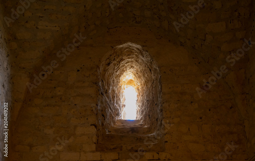 Schilderij op canvas Dramatic light and shadow inside a historic limestone embrasure at Qaitby Castle