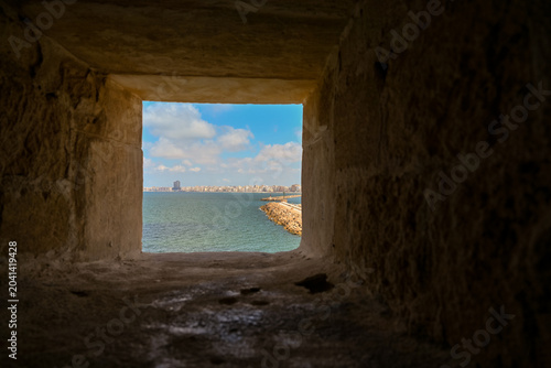 Bild auf Leinwand View of the Mediterranean sea and Alexandria cityscape through a fortress shooti