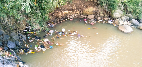 Canvastavla Accumulation of plastic litter and garbage floating on murky river water near th