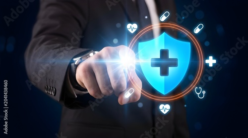 Hand holding glowing medical cross symbol with digital health icons and futuristic interface