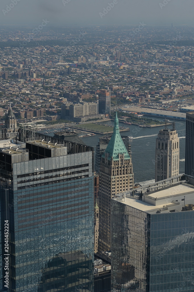 Obraz premium Skyline Of Manhattan With Glass Towers Shining Under Midday Sunlight And Shadows new york
