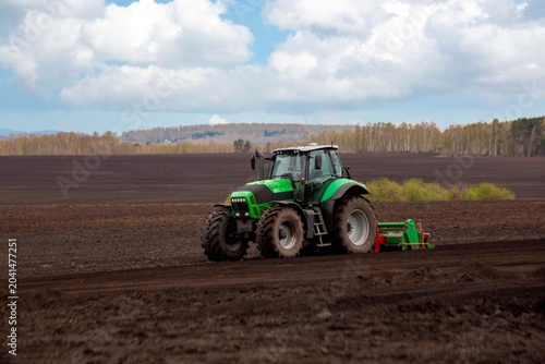 A tractor plowing a field in spring. Agriculture, farming.
