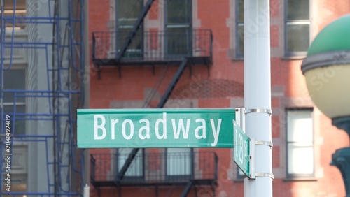 New York City Broadway street sign in Manhattan Midtown, United States. Urban road sign, traffic sign. Building architecture in Flatiron district. Crossroad with 5 fifth avenue. Subway metro lamp