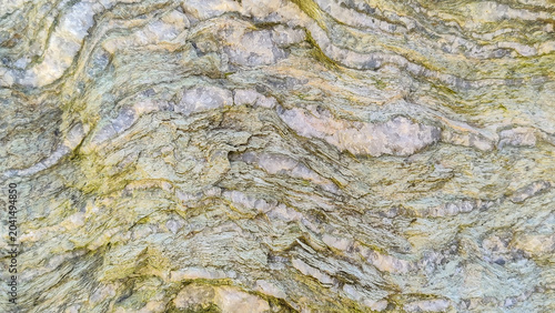 Fotografie Natural layered mineral stone texture background with green schist and quartz ve