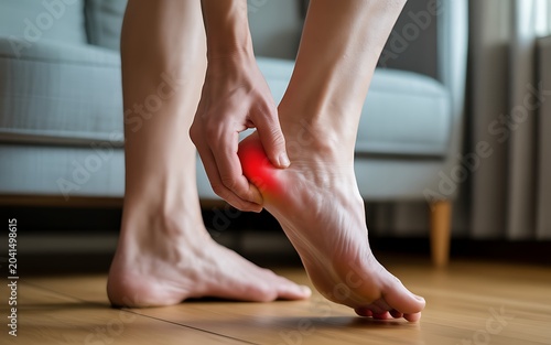 Person holding foot heel with red pain symbol plantar fasciitis heel spur discomfort.