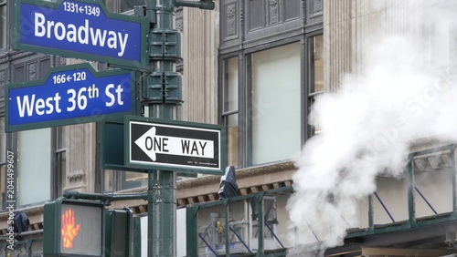 New York City Broadway and 36 street sign on Manhattan, United States. Urban road sign in american city. Traffic sign in Midtown of NYC. Building architecture, district near Herald Square. Hot steam