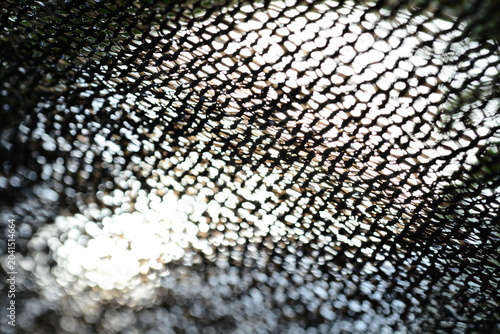 Canvas Print Black shading net texture background with bright sunlight flare and bokeh effect