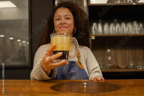 Tableau sur toile Bartender offering a refreshing dark stout beer mug in a cozy pub, celebrating c