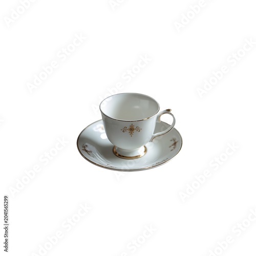 An elegant white porcelain teacup with delicate gold filigree detailing resting on a matching saucer