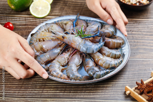 Tableau sur toile Fresh Raw Shrimp Selection on Plate with Lime and Spices Ready for Cooking