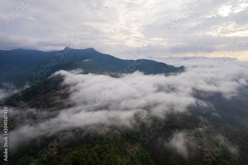 Landscape of Morning Mist with Mountain Layer. mountain ridge and clouds in rural jungle bush forest