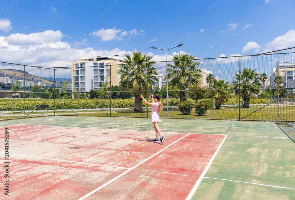 Fototapeta premium Woman playing tennis on outdoor court. Concept of fitness, recreation, active lifestyle, sport and wellbeing