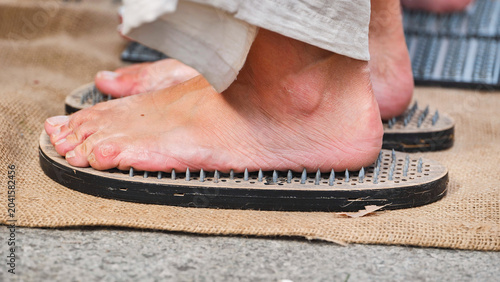 Quadro su tela Sadhu standing on nail board practicing yoga in India