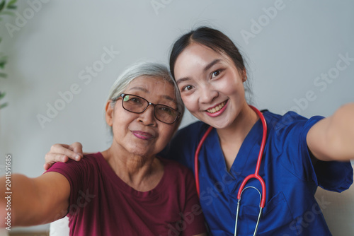 Nurse and senior woman smiling taking a happy selfie